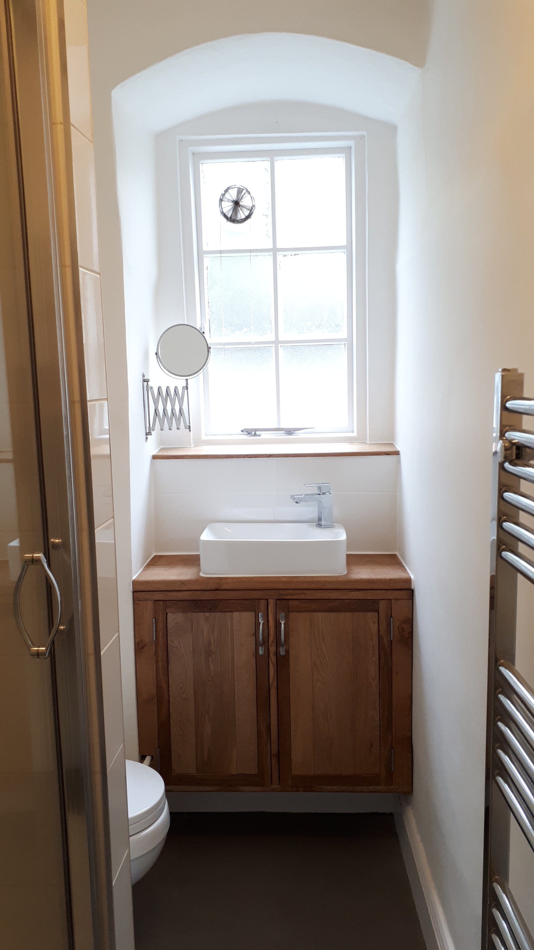 A wooden vanity unit with a top mounted wash basin.